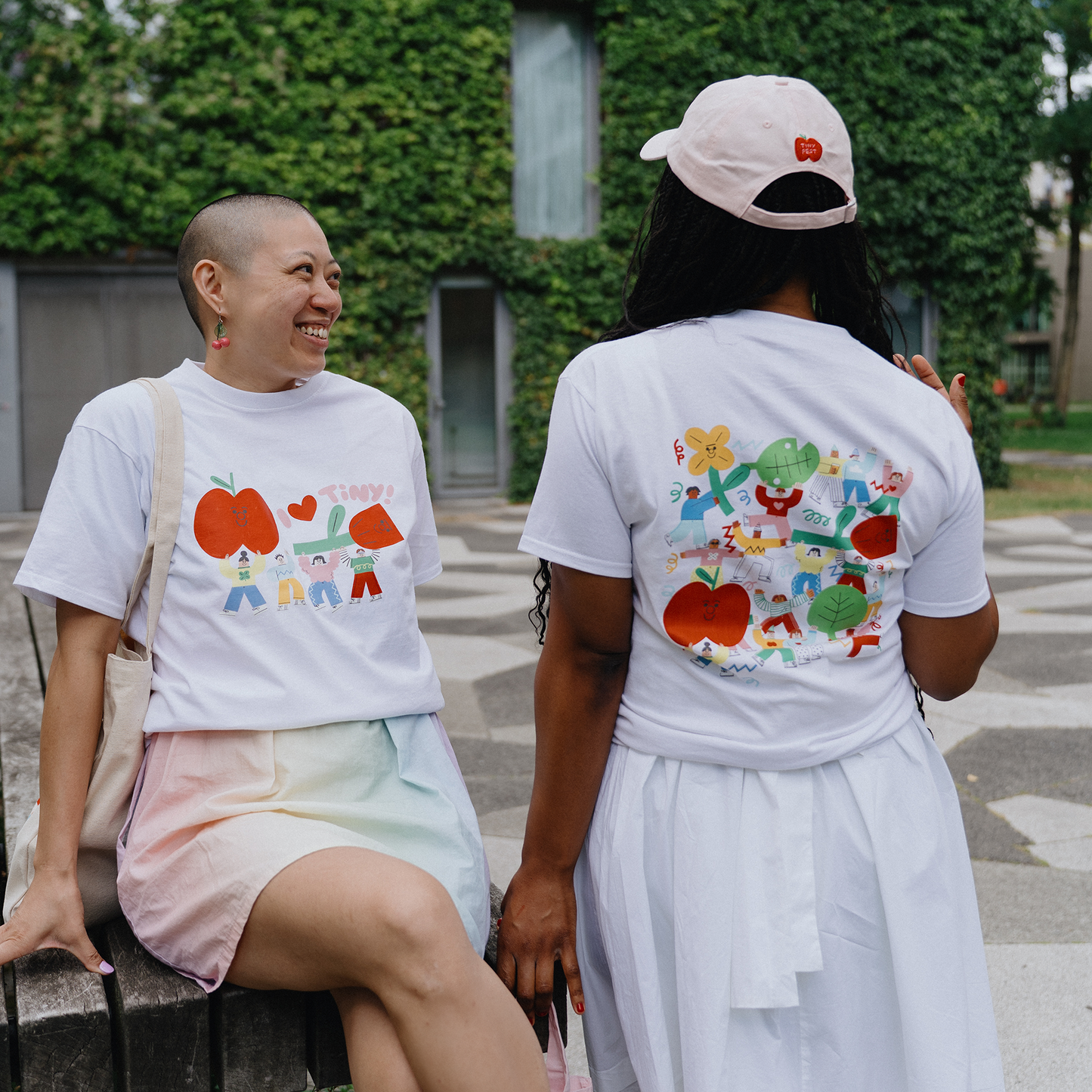 Two people wearing t-shirts with colorful designs outdoors.