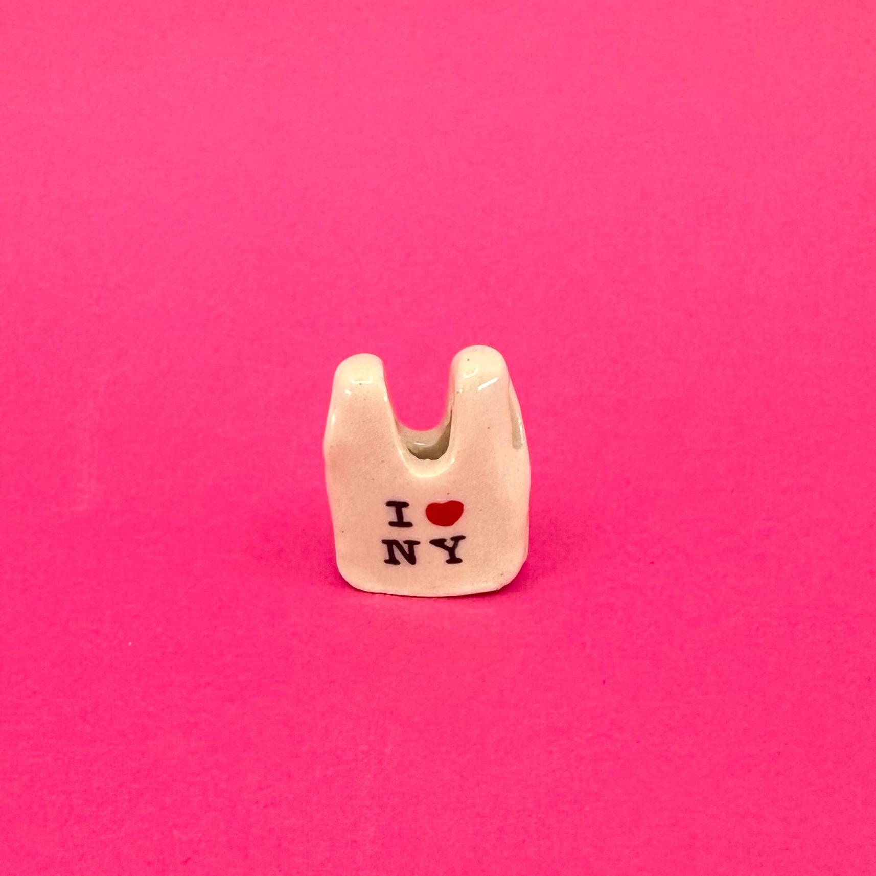 Small white bag charm with 'I ❤️ NY' text on a pink background