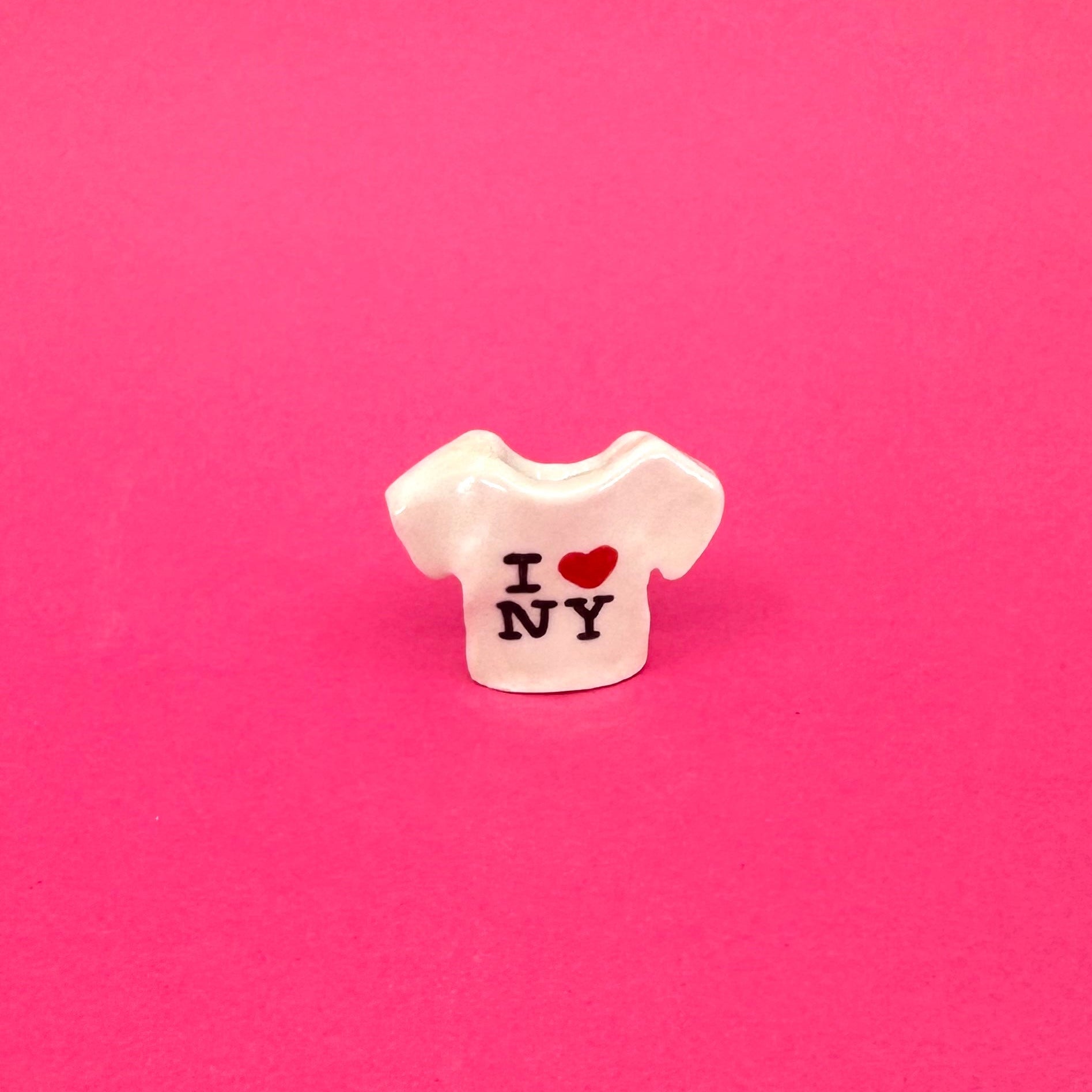 Small white ceramic t-shirt mini vase with 'I ❤️ NY' text on a pink background